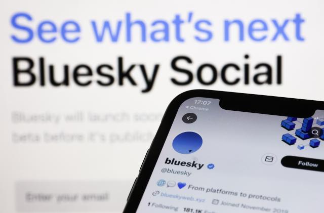 Bluesky Twitter account displayed on a phone screen and Bluesky Social website displayed on a screen in the background are seen in this illustration photo taken in Krakow, Poland on November 5, 2022. (Photo by Jakub Porzycki/NurPhoto via Getty Images)