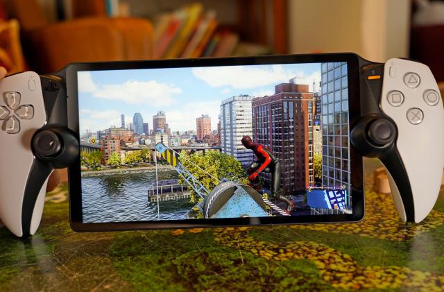 Image of the PlayStation Portal on a kitchen countertop with a still image from Marvel's Spider-Man 2 on the screen.