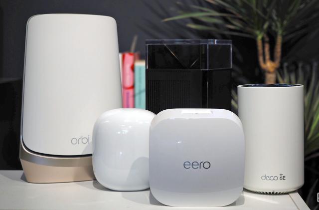 Family image of several WiFi routers including a Netgear Orbi, Nest WiFi Pro, Eero Pro, ZenWifi Pro and Deco XE75.