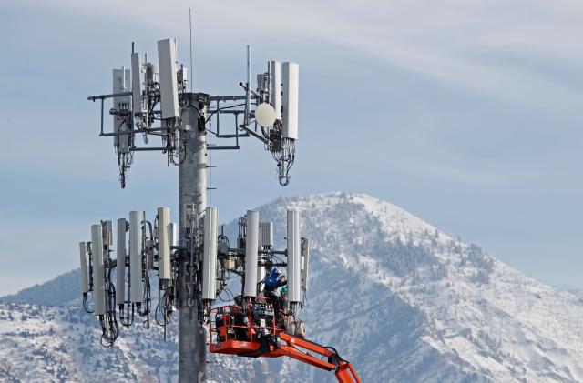 TOPSHOT - A contract crew for Verizon, works on a cell tower to update it to handle the new 5G network in Orem, Utah on December 10,  2019. - The new 5G cellular network will substantially increase cellular network speeds, opening up new markets for business and individuals. (Photo by GEORGE FREY / AFP) (Photo by GEORGE FREY/AFP via Getty Images)