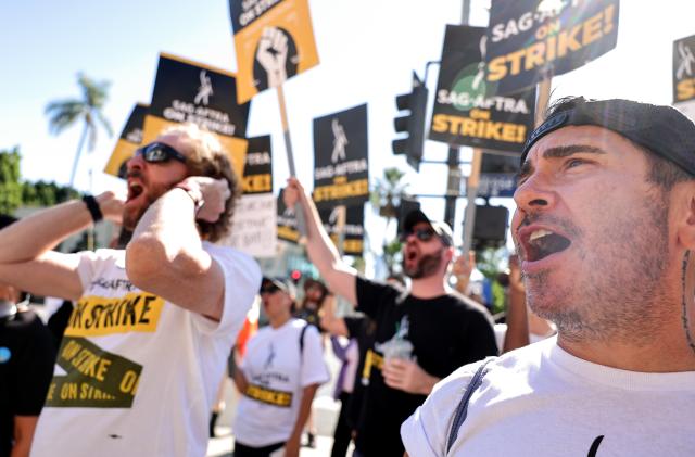 LOS ANGELES, CALIFORNIA - NOVEMBER 08: SAG-AFTRA member Brandon Alameda (R) chants as SAG-AFTRA members and supporters demonstrate outside Paramount Studios on day 118 of their strike against the Hollywood studios on November 8, 2023 in Los Angeles, California. Contract negotiations between the actors union and the Alliance of Motion Picture and Television Producers (AMPTP) have inched closer to a deal, with a reported breakthrough on the use of artificial intelligence (AI), in the strike which began on July 14. (Photo by Mario Tama/Getty Images)